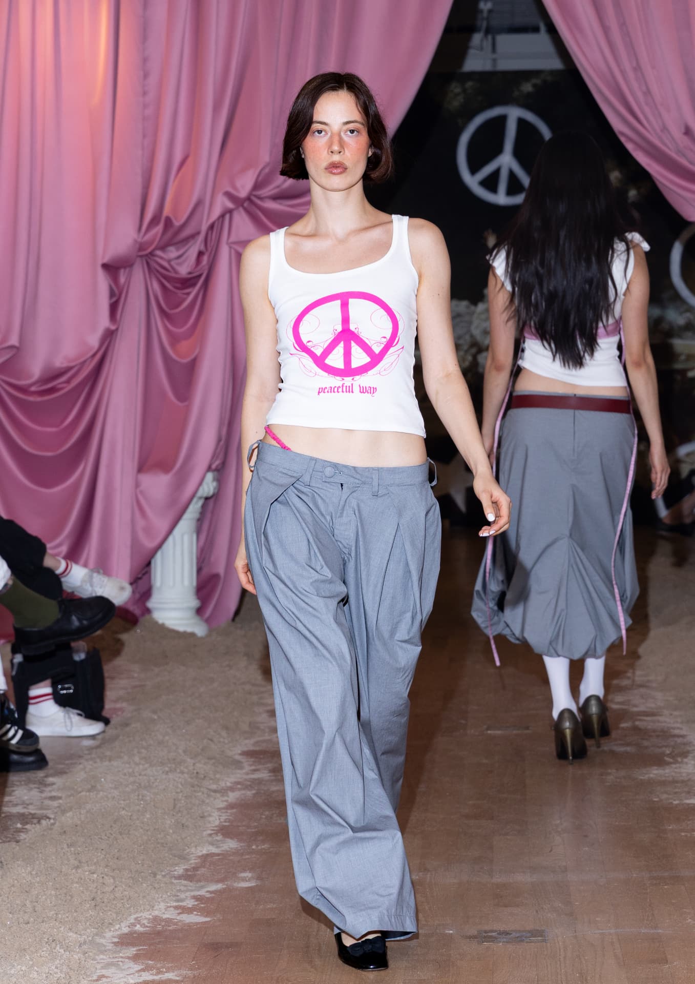 Ella Mae SS27 — white peace-sign tank with loose grey trousers