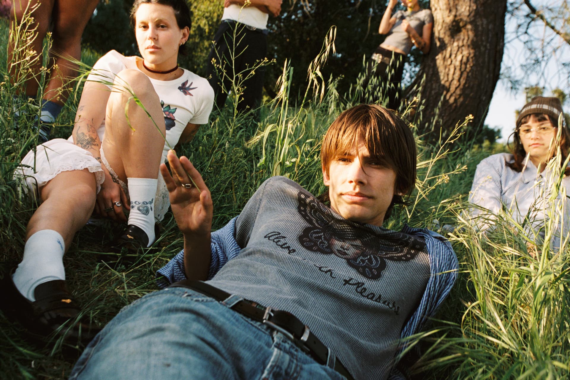 Janky Inc. SS25 — group of friends relaxing on a green hillside