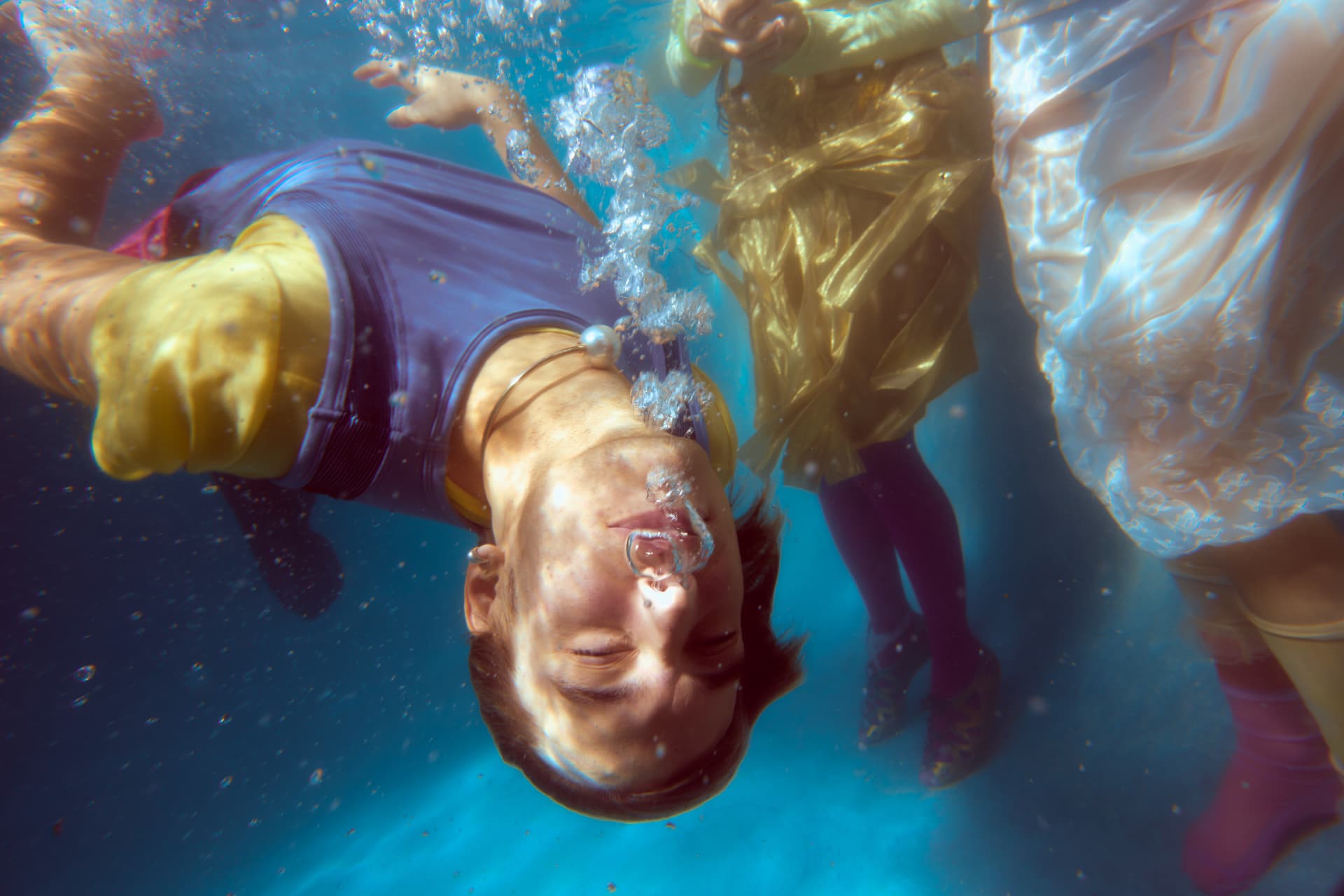 GOODBYE SUMMER — a swimmer floating upside down surrounded by rising bubbles