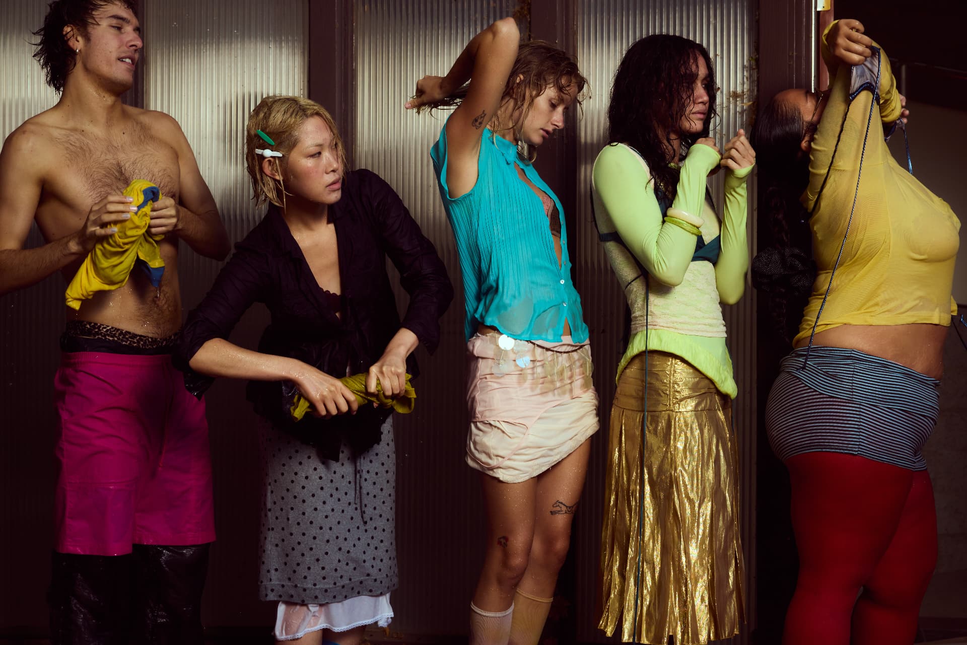 GOODBYE SUMMER — five people in damp eclectic garments lined up before a ribbed wall