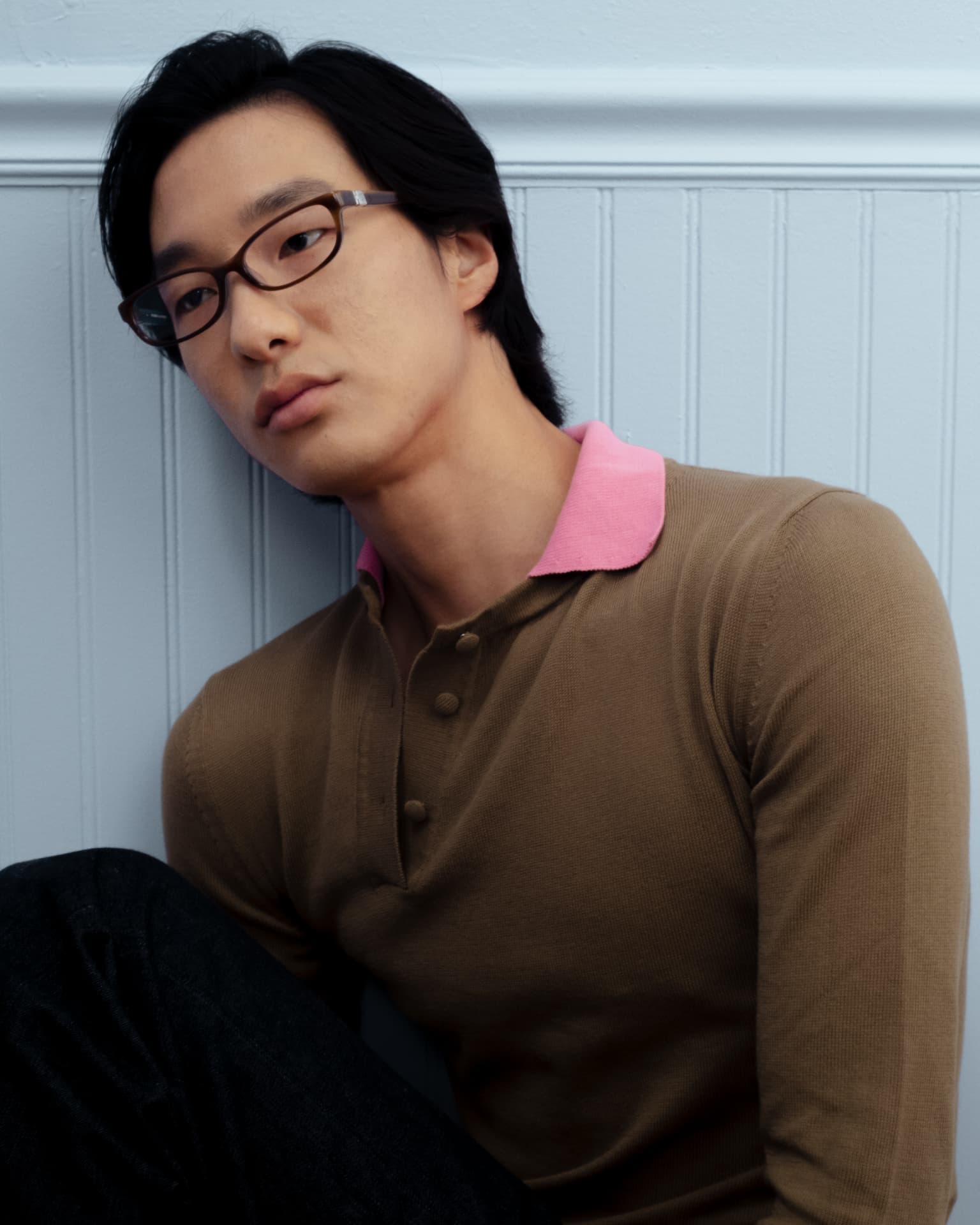 Bonnie Clyde — man with brown-rimmed glasses in a brown long-sleeve polo against a light blue paneled wall