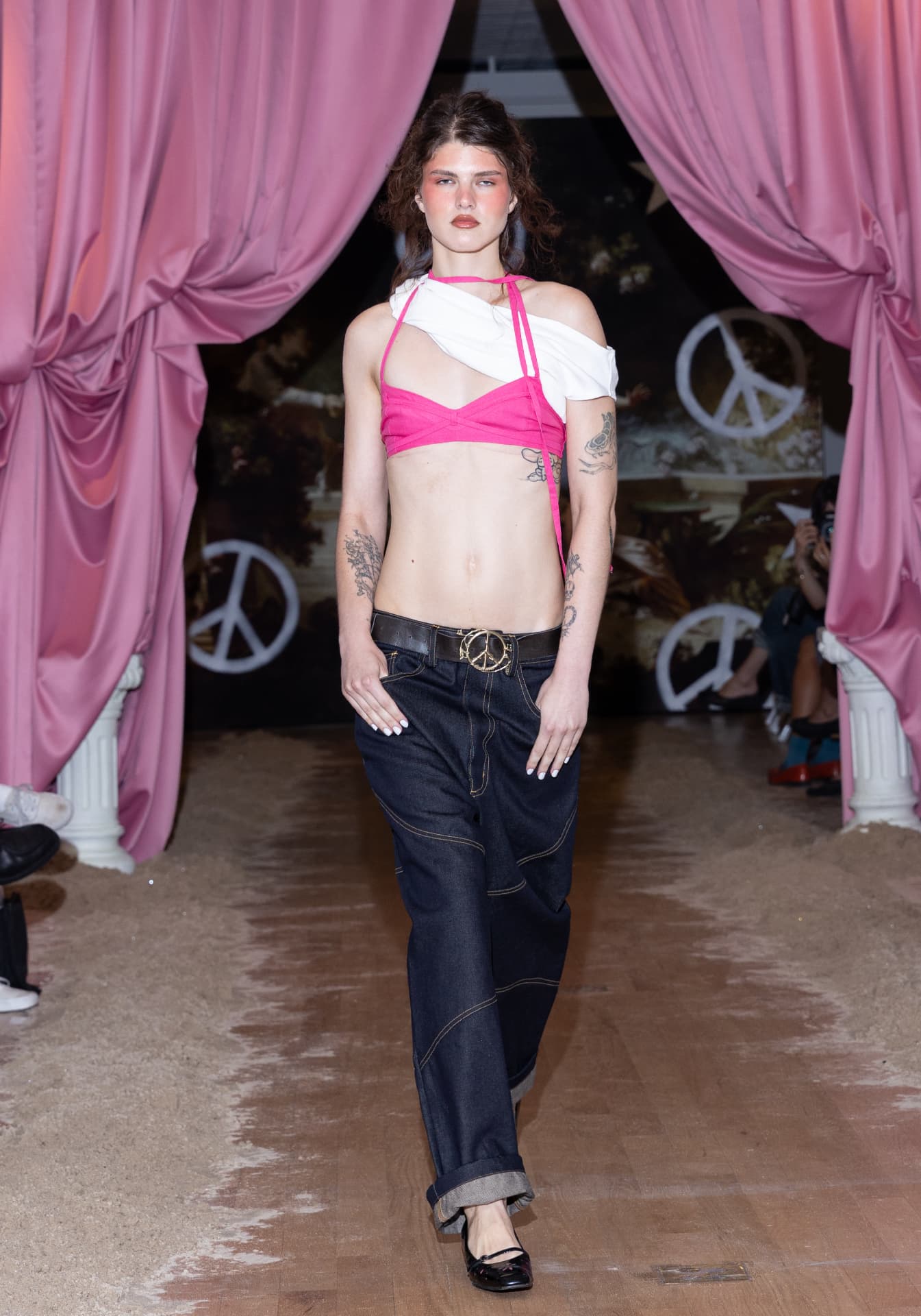 Ella Mae SS27 — dark denim with a gold peace-sign buckle and hot pink bikini top